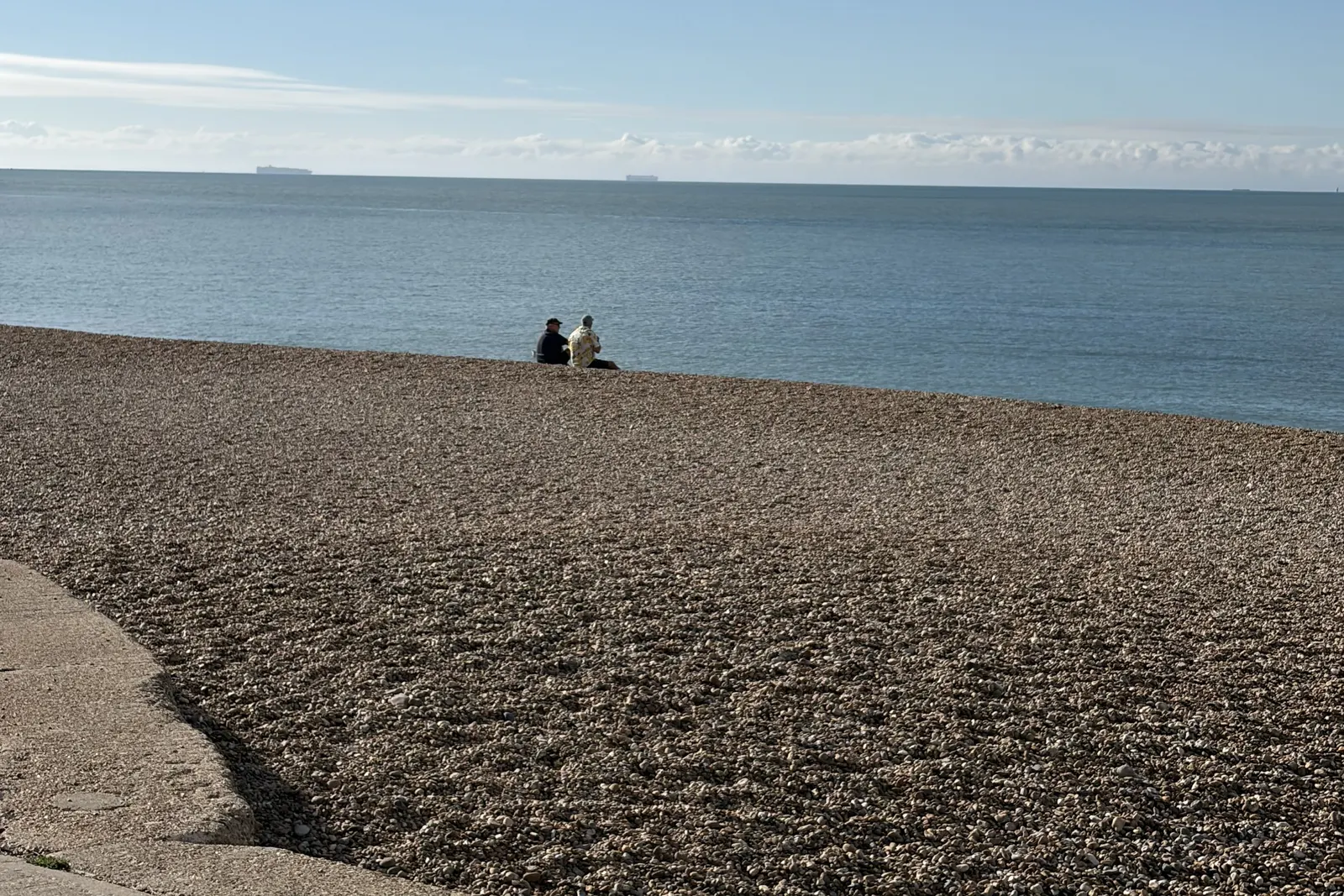 Sandgate's shingle beach and calm sea under a blue sky, a short walk from The Ship Inn