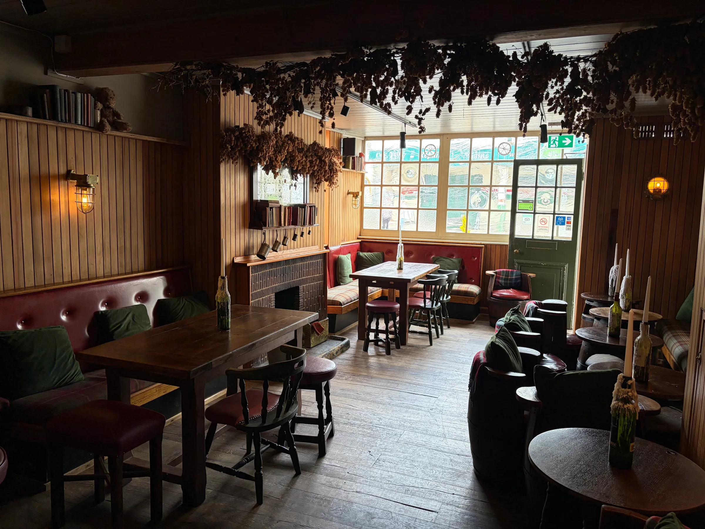 The lounge at The Ship Inn, Sandgate, with leather armchairs, dining tables and hops above the windows