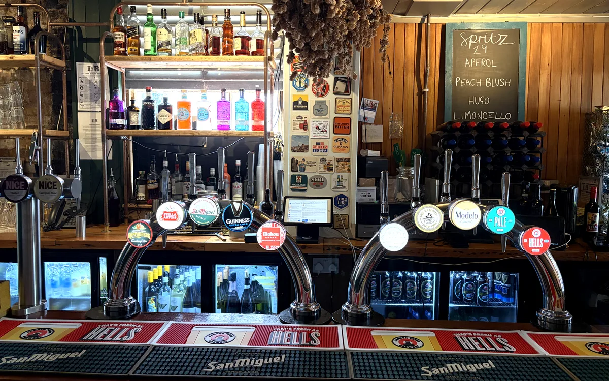 The bar at The Ship Inn: a row of beer taps in front of a back bar lined with bottles