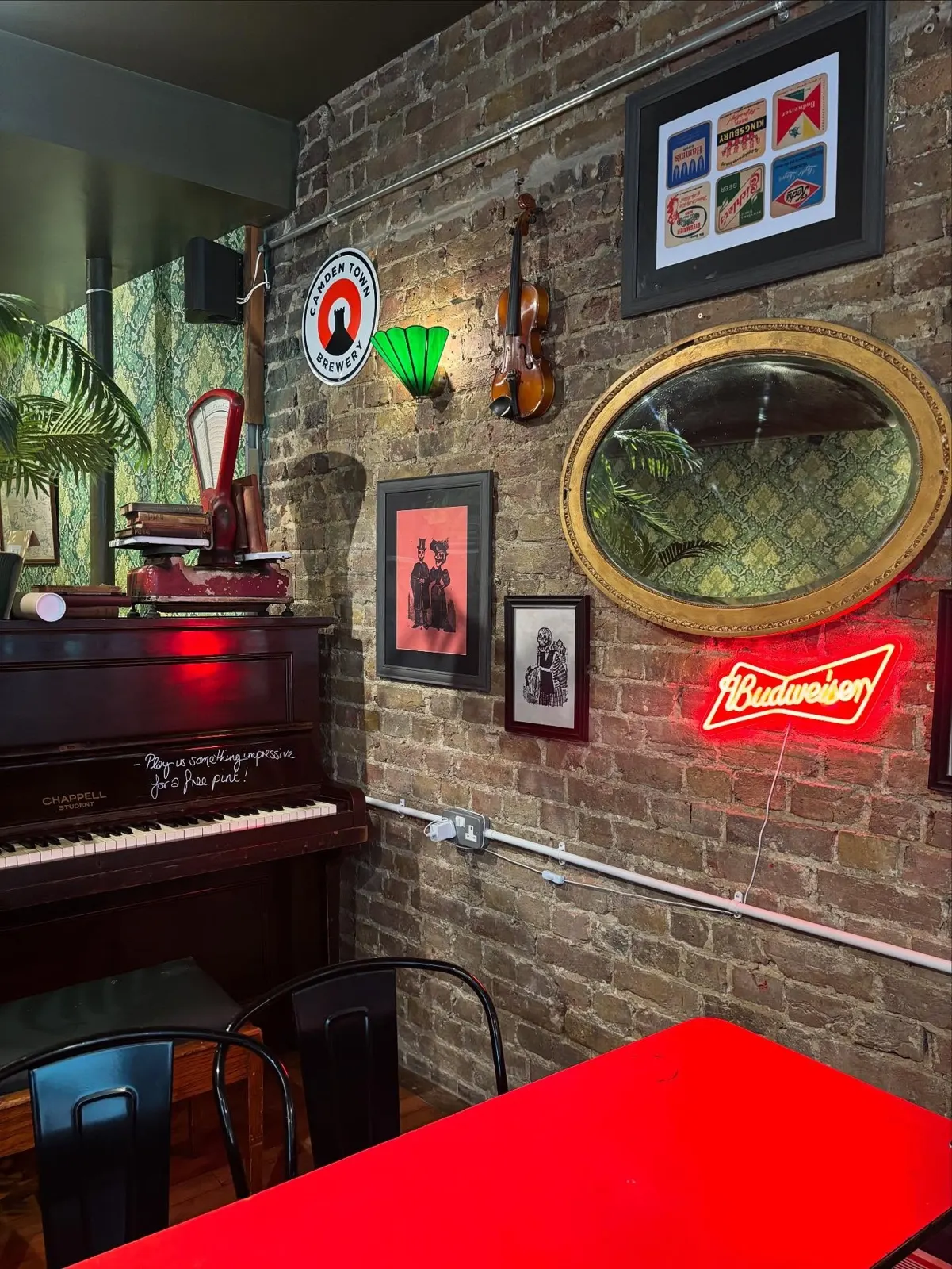 Piano by the brick wall with a mirror and neon sign